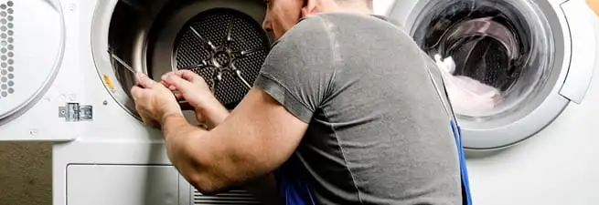 Dryer repair technician fixing a clothes dryer drum in Aurora, CO