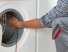 Dryer repair technician diagnosing and servicing a clothes dryer in Aurora, CO