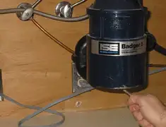 Garbage disposal repair technician tightening the mounting ring under a sink in Aurora, CO