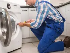 Washing machine repair technician servicing a front-load washer in Aurora, CO