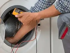 Washing machine repair technician testing a front-load washer with diagnostic tools in Aurora, CO