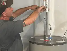 Water heater repair technician tightening supply line connections in Aurora, CO